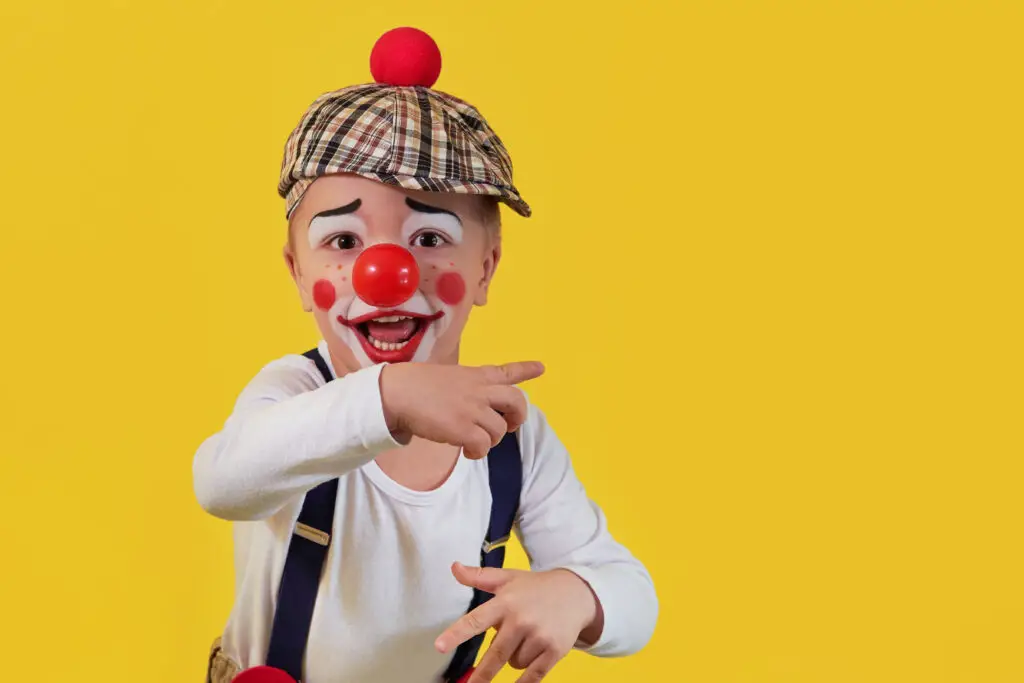 Child clown costume, yellow background. Red nose.
