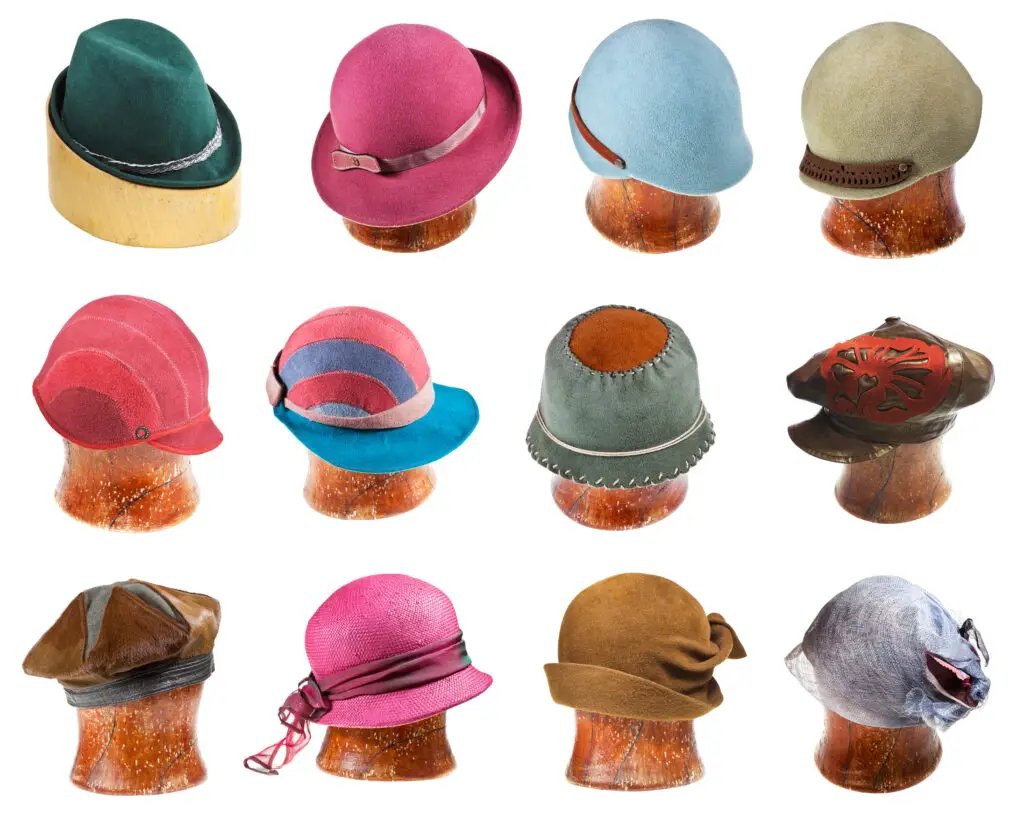 Lot of different styles of hats on wooden blocks.