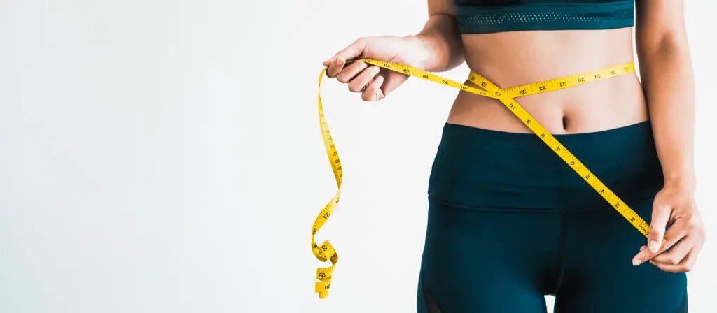 Close up shot of someone taking body measurements on white background.
