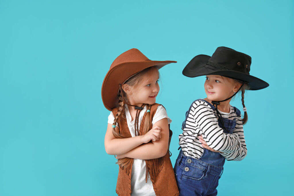 Children wearing cowboy costumes with blue background - Start Sewing