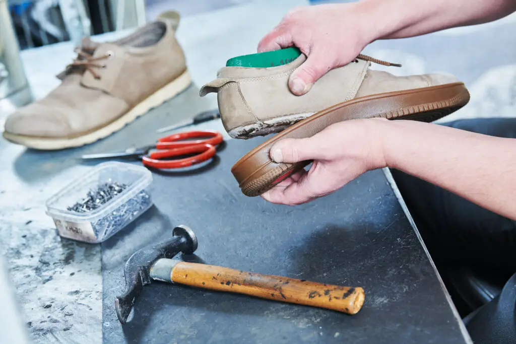 Reparing sole on an cream shoe.