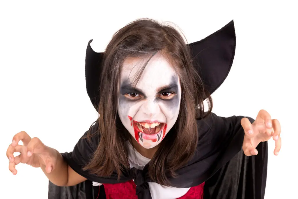 child with face-paint and vampire costume, white background